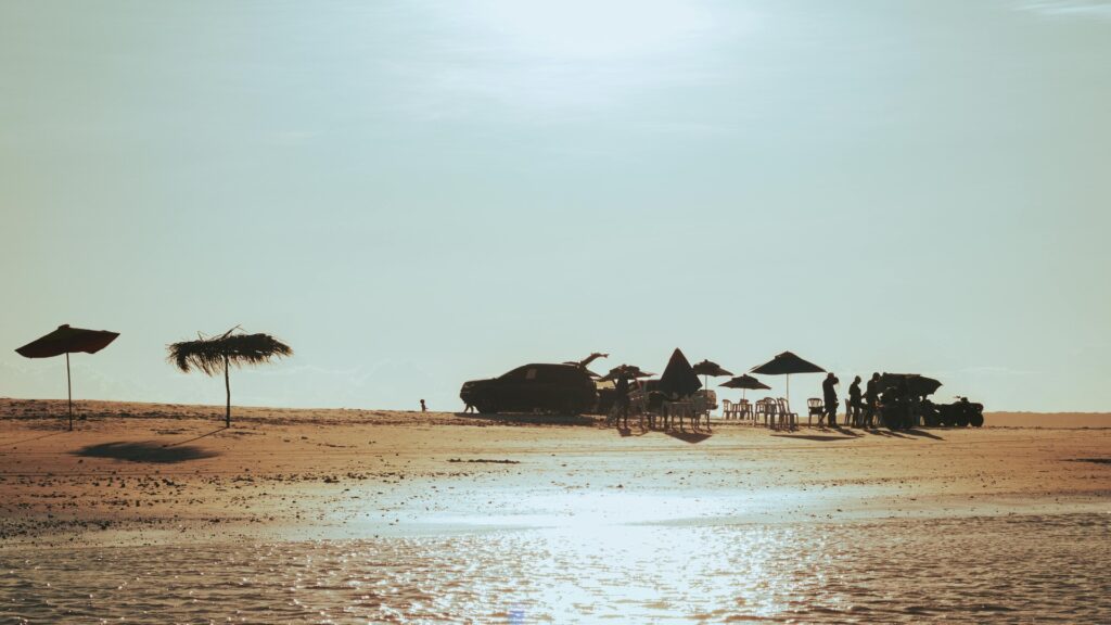 trucks with sun umbrellas on the beach at sunset